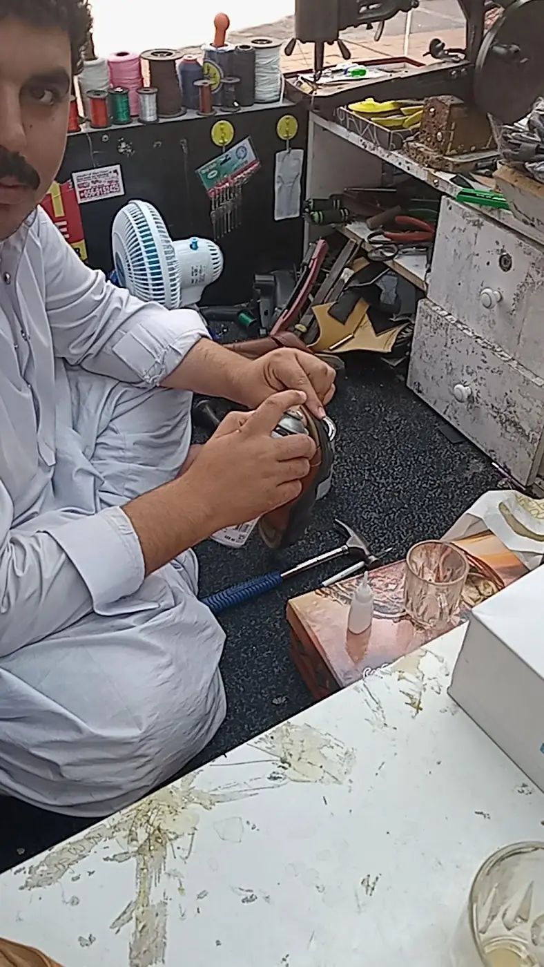 Repairing a suitcase at the Al Amwaj Footwear workbench